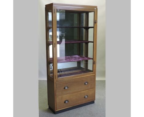 A mid 20th century light oak shop display cabinet, with a glazed upper section and drawers below, 91cm