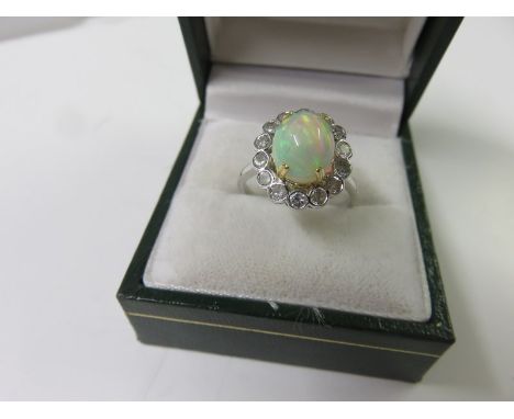 FINE OPAL & DIAMOND RING, 18ct white gold ring set a cabochon opal surrounded by a cluster of 14 diamonds totalling approxima