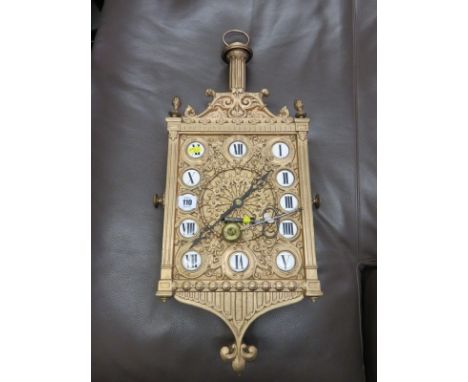PUGINESQUE, a gilt metal surround Continental hanging wall clock with inset enamel numbers, 26" height