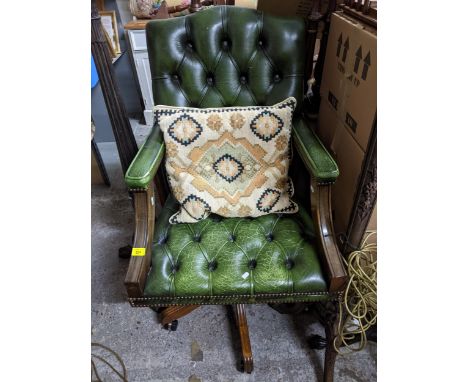 A mahogany framed and green leather upholstered button back swivel armchair, with loose cushionLocation: 