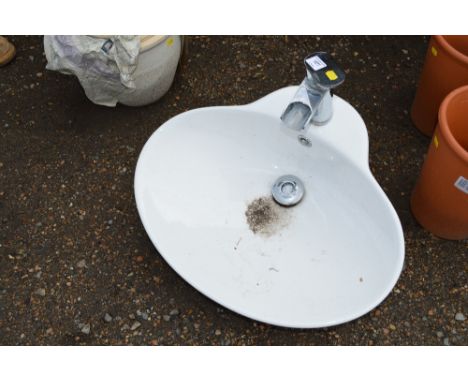 A ceramic sink with waterfall tap