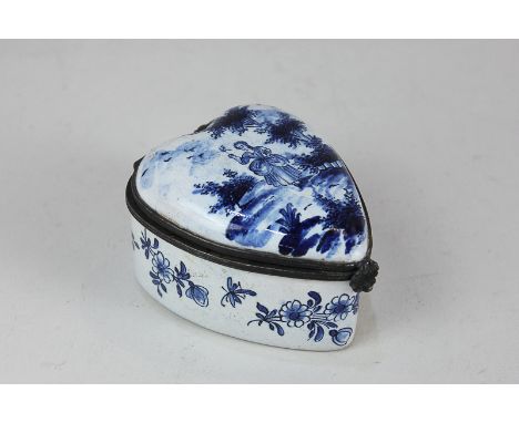 A 19th century Delft enamel heart-shaped patch box decorated in blue with a lady in a garden, on white ground, initial A vers