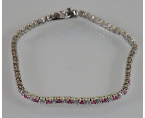 A silver line bracelet set with cubic zirconia and ruby colour stones