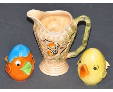 A Wade jug, relief decorated with oak leaves & acorns, together with a Goebel W.German salt and pepper modelled as happy chic