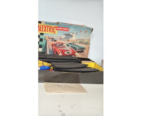 Vintage Scalextric slot car racing set with original box, track pieces, controllers, and cars. Includes additional boxed acce