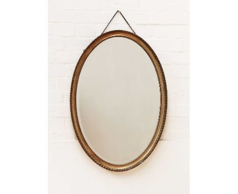 A George III-style oval wall mirror,contemporary, with a bevelled plate,52cm wide83cm highCondition report: light cosmetic we