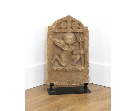 An Indian sandstone panel stele depicting Varahi,19th century, the goddess kneeling and holding a trident, raised on a modern