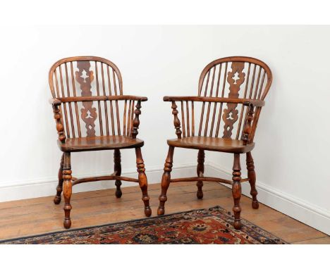 A pair of yew and elm low hoop back Windsor chairs, mid-19th century, Nottinghamshire, each with a central fir tree motif spl