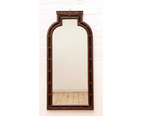 A Gothic oak and ebonised wall mirror,19th century and later, the frame with a domed top and set with flower head motifs, the