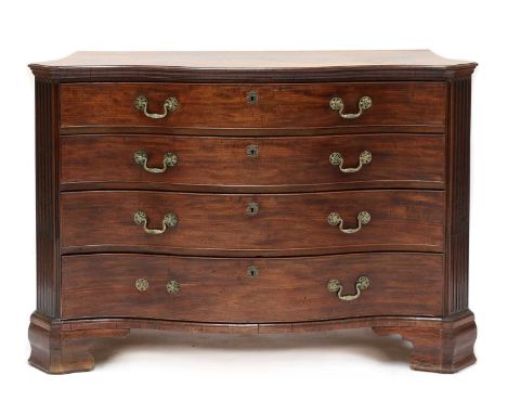 A George III mahogany serpentine commode, c.1770, with canted fluted and reeded angles, cast brass handles, on shaped bracket