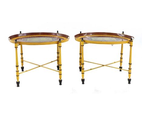 A pair of Regency-style yellow-painted toleware side tables,20th century, the oval tray tops transfer-decorated with neoclass