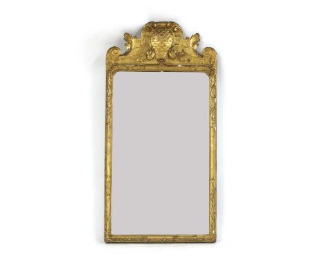 A Queen Anne carved giltwood and gesso pier mirror,early 18th century, the shaped cresting centred with a pineapple, flanked 