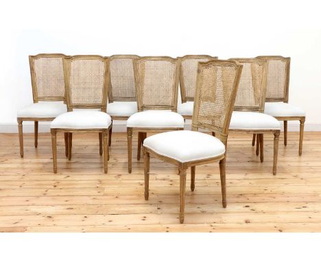 A set of eight modern bleached oak dining chairs,by Nordic Style London, each with a caned back and upholstered serpentine se