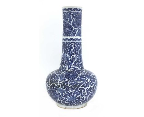 A Chinese porcelain bottle vase,Kangxi period, of ovoid form with elongated neck, painted in underglaze blue with flower head