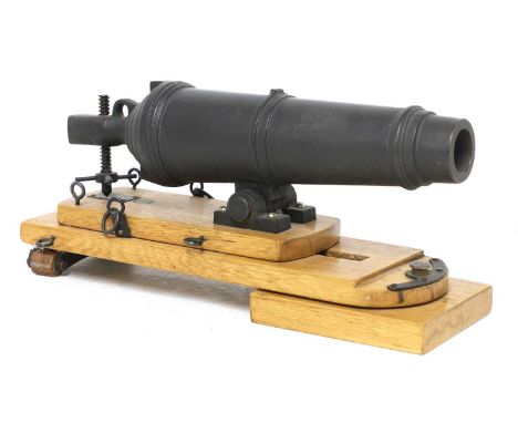 A model of a late 18th century naval carronade,cast iron barrel, on a wooden sliding and swivelling carriage,30cm wide 10cm d
