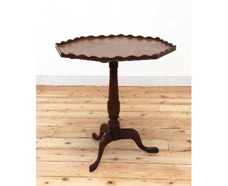 An oak octagonal tripod table,early 19th century, the top with a wavy inlaid galleried edge, on baluster support and three ou