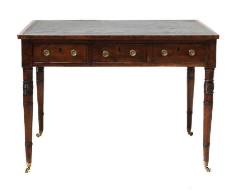 A Regency mahogany library table, with a leather cloth-lined surface, three frieze drawers and dummy verso, on ring-turned co