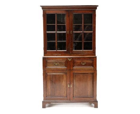 A George II chestnut estate cabinet, with glazed doors and candle slides above a fitted writing drawer and further drawers, e