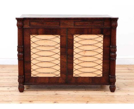 A George IV rosewood collector's cabinet in the manner of Gillow,the crossbanded and strung shaped top above two cockbeaded f