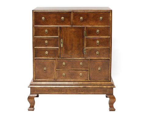 A walnut chest on stand, early 18th century style, consisting of twelve various drawers around a central cupboard, each with 