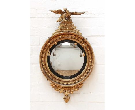 A Regency giltwood convex mirror, the ribbon-tied frame surmounted by an eagle, with ball detail,78cm highCondition report: P
