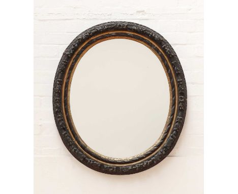 A carved giltwood and ebonised oval wall mirror,19th century, deeply carved with foliate motifs,84cm wide97cm highCondition r