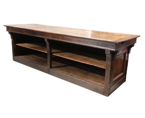 A French draper's table,late 19th century, the planked top with cleated ends over open shelves beneath,273cm long90cm deep85c