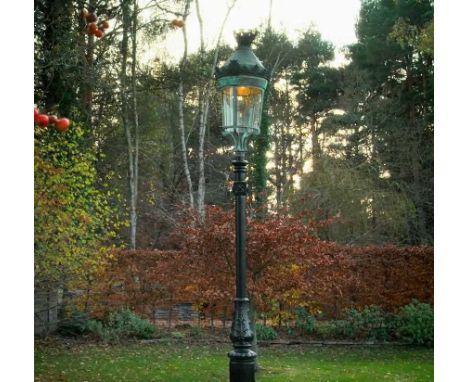 A Parisian cast iron and copper street lamp,late 19th century, with a castellated top over a glass shade, on scroll supports 