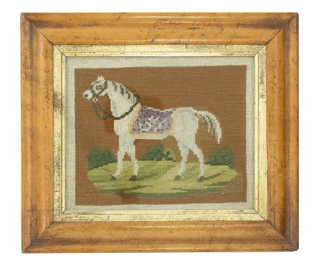 A needlework panel, mid-19th century, depicting a standing grey horse in a naturalistic setting,18 x 22cm, within a maple fra