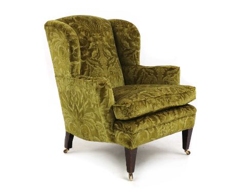 A wingback armchair,first quarter of the 20th century, upholstered in green floral Zoffany velvet, raised on tapering square 