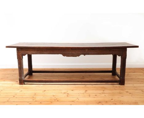 An oak refectory table,17th century and later, the plank top with cleated ends, above a moulded and shaped apron, raised on c