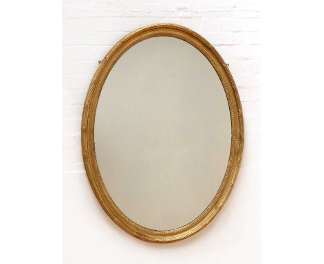 A George III-style oval wall mirror,19th century, with a reeded and ribbon-tied moulded frame, 92cm wide125cm highCondition r
