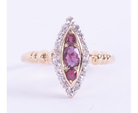 An antique 18ct yellow gold marquise shaped ring set with a central oval cut ruby &amp; two off round cut rubies, total weigh