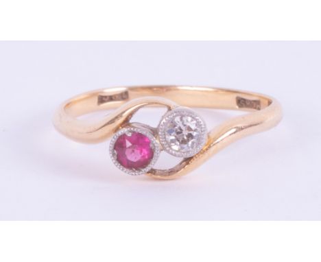 An 18ct yellow gold crossover style ring set with a round cut diamond and ruby, 2.56gm, size N.