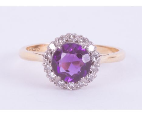 An 18ct yellow gold &amp; platinum cluster ring set with a central round cut amethyst, approx. 1.50 carats, surrounded by sma