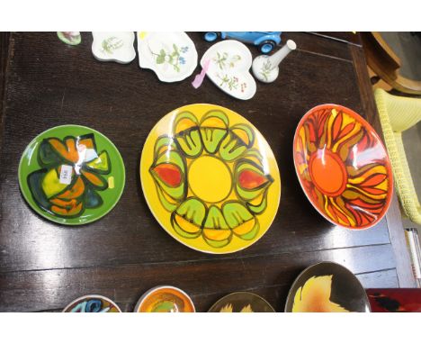A Poole 'Delphis' patterned pottery bowl on red/orange ground, a Poole 'Delphis' charger on yellow ground and a Poole 'Delphi