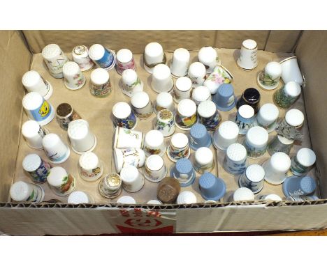 Approximately seventy modern ceramic thimbles together with a glass dome display and a set of small shelves.