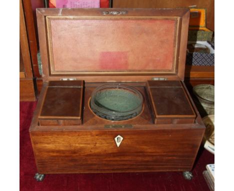 A Georgian mahogany rectangular tea caddy with two lidded compartments and a central glass mixing bowl, on claw feet, 31cm wi