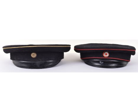 2x Model 1867 Imperial German Peaked Caps, the first being of black cloth with red piping to the crown and bordering central 