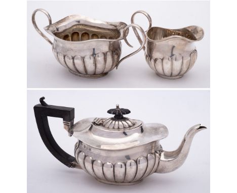 An Edward VII silver three-piece batchelor's tea service, maker Joseph Gloster Ltd, Birmingham, 1909: of oval lobed form on a
