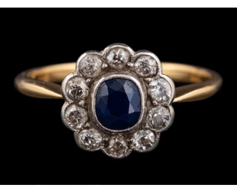 A sapphire and diamond ring,: the central oval cut sapphire collet set within a surround of old cut diamonds, approximately 0