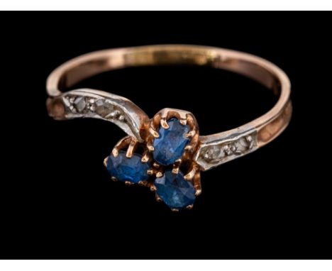 A sapphire and diamond crossover ring,: set with three oval cut sapphires between rose cut diamond set shoulders, ring size O