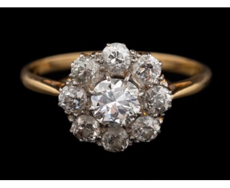 A diamond cluster ring,: the central old brilliant cut diamond, estimated to weigh 0.50 carats, claw set within a surround of