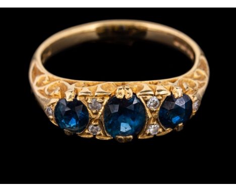 An 18 carat gold sapphire and diamond ring,: the three oval cut sapphires with eight cut diamonds in between, stamped 18 with