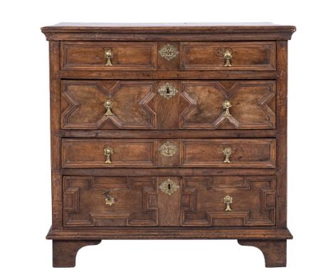 A 17th Century oak rectangular chest:, the top with a moulded edge, containing four long geometrically moulded panel drawers 