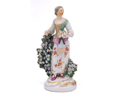 A Derby figure of a girl emblematic of Summer: holding a sheaf of corn and a flask in her left hand, on scrollwork base with 