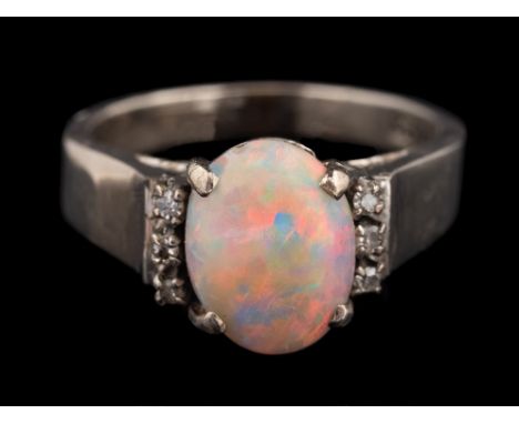 An opal and diamond ring,: the oval cabochon opal claw set between eight cut diamond set shoulders, stamped 18k, ring size K 