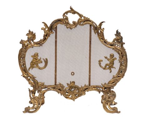A gilt metal and mesh firescreen in Louis XV style, late 19th /early 20th century,: of cartouche form, the surround and four 