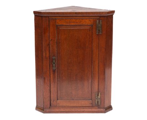 A George III oak hanging corner cupboard, last quarter 18th century,: with moulded top and bottom and fielded panel door, 94c