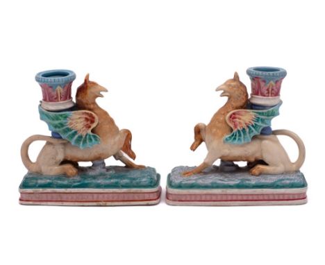 A pair of Royal Worcester majolica Griffin candlesticks: each winged griffin supporting a candleholder, on stepped rectangula